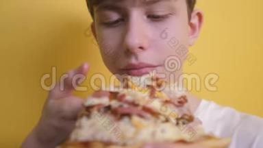 披萨。 快乐的<strong>青</strong>少年男孩<strong>吃</strong>一片披萨的概念。 十几岁的男孩饿了<strong>吃</strong>一片披萨。 慢速视频